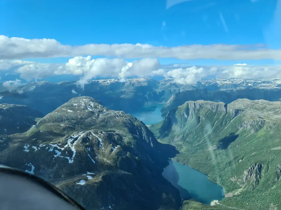 Blick aus einem Privatflugzeug auf Seen und Alpen